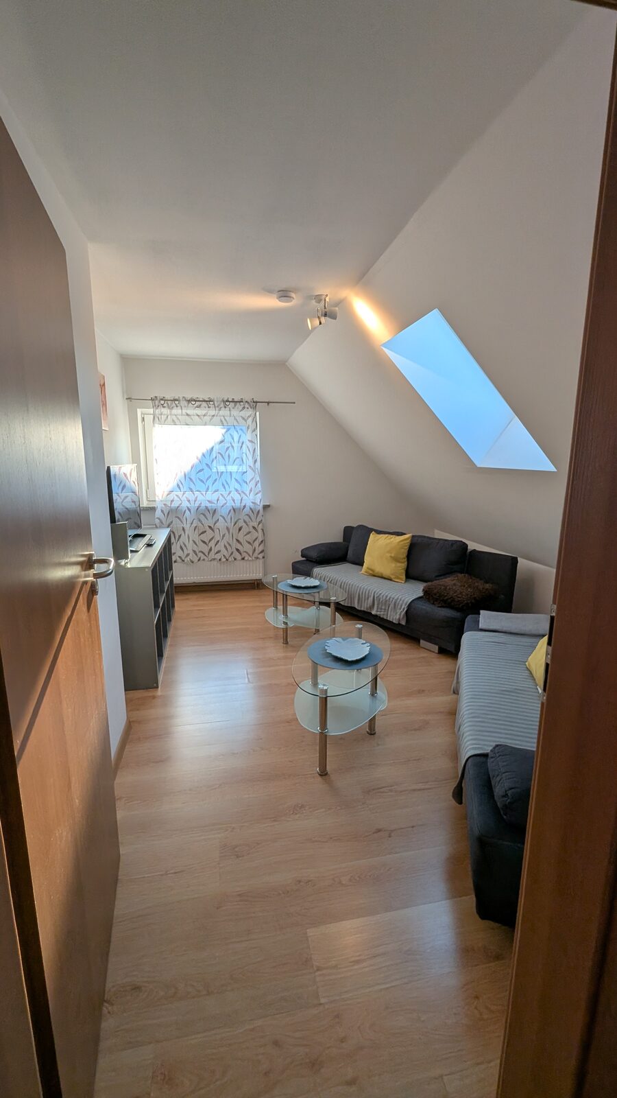 Wohnzimmer der Unterkunft mit Sofa, Tisch und Dachfenster